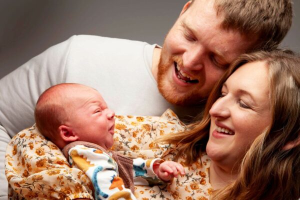 Photo of mum and dad holding newborn baby